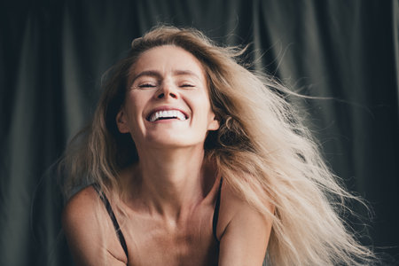 Studio no retouch photo of dreamy stunning lady dressed lingerie enjoy air blowing accepting imperfect skin isolated khaki cloth backgroundの写真素材