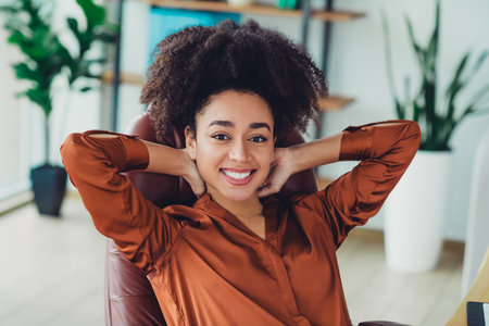 Young professional woman enjoying a break in a loft styled office workspace with modern design features and natural daylight settingの写真素材