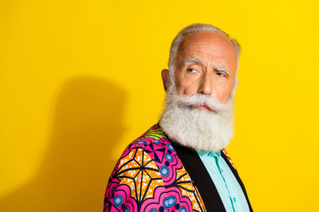 Profile portrait of minded nice aged man look empty space wear classy blazer isolated on yellow color backgroundの写真素材