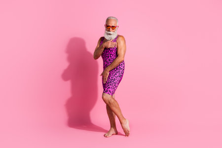 Full length photo of charismatic elderly cool man cover body shy flirty wear leopard print overall isolated on pink color backgroundの写真素材
