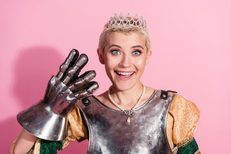 Portrait of a joyful woman in historical attire with modern twist against a pink background showcasing positivityの写真素材