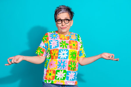 Portrait of nice aged lady shrug shoulders wear t-shirt isolated on turquoise color background