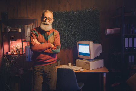 Experienced senior professional confidently standing in a cozy home office with vintage computer and...