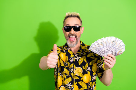 Charismatic Gentleman Holding a Fan of Money With Thumbs Up Gesture in Style on a Green Background...