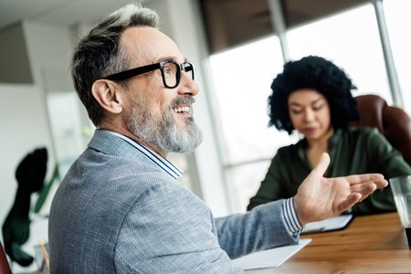 Diverse business team in a formal meeting discussing project strategies in a modern office environmentの写真素材