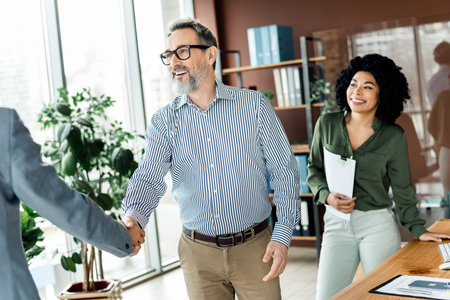 Professional teamwork in a bright office workspace showcasing collaboration between coworkers during...