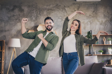 Photo of lucky attractive woman man dressed casual shirts smiling dancing indoors house apartment roomの写真素材