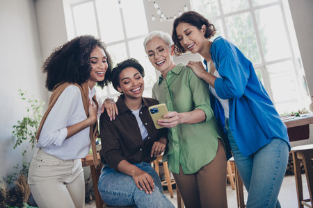 Photo of corporate four colleagues women feminists community use device pause have fun leadership...