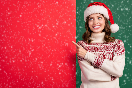 Photo of attractive cheerful girl toothy smile look direct finger empty space x-mas poster isolated on green color backgroundの写真素材