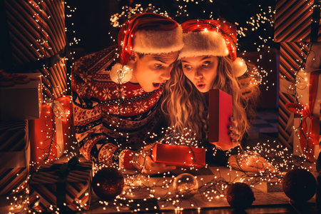 Full size photo of lovely young couple lying floor shocked open gift dressed christmas outfit day light home party decoration interior roomの写真素材