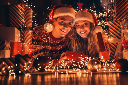 Full size photo of lovely young couple lying floor open present box dressed christmas outfit day light home party decoration interior roomの写真素材