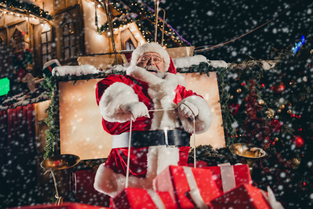 Photo of funky cool santa wear read costume hat bought gifts market sitting driving sleigh carry miracle illuminated streets outdoorsの写真素材