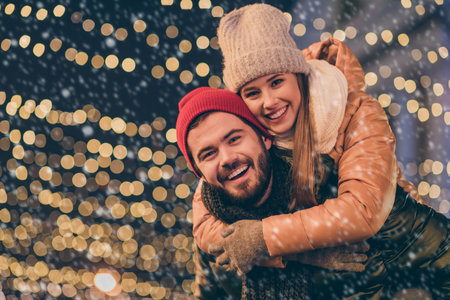 Photo of bonding couple boyfriend piggyback girlfriend under x-mas tradition christmas outside...