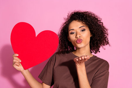 Photo of charming lovely pretty girl wear brown trendy clothes showing paper card heart isolated on pink color backgroundの写真素材