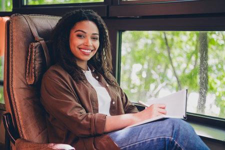 Portrait of corporate business lady sit leather chair hold notepad wear shirt modern interior office indoorsの写真素材