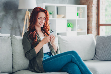 Photo of positive good mood woman dressed casual shirt chatting instagram twitter telegram facebook indoors house apartment roomの写真素材