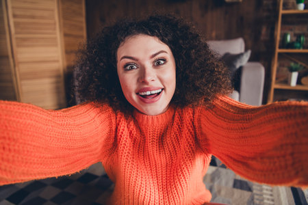 Portrait of nice young girl good mood make selfie wear orange sweater modern loft interior flat indoorsの写真素材