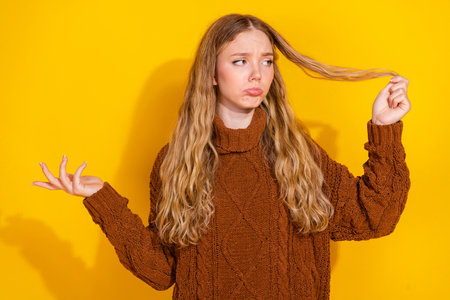 Photo of pretty young woman hold look damaged hair wear pullover isolated on yellow color background