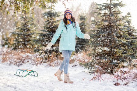 Full size photo of young beautiful charming pretty girl go walk with sledge in park forest having...