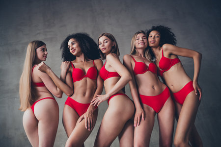 Photo of five pretty lovely model women cuddle enjoyment wear red lingerie grey wall studio backgroundの写真素材