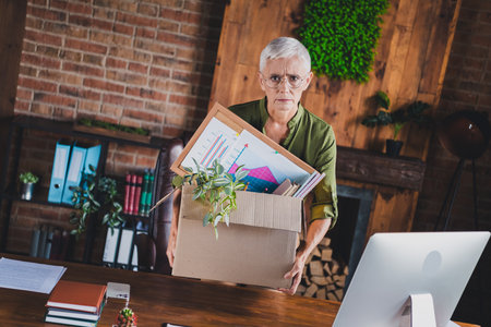 Photo of charming jobless senior lady dressed shirt need job office workplace workstation loft interior indoorsの写真素材