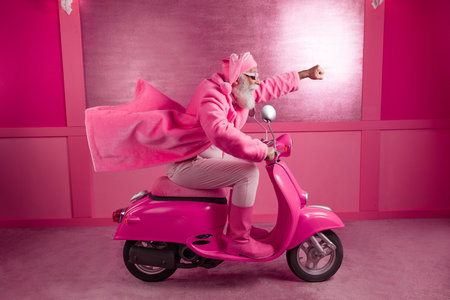 Full size portrait of excited extravagant santa ride scooter wear pink boots bathrobe studio corridor backgroundの写真素材