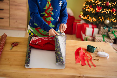 Photo of cute retired woman wearing blue clothes packing gift magic atmosphere indoors roomの写真素材