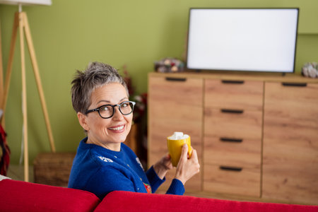 Photo of lovely cute woman wear blue sweater sit divan drink cacao relax rest christmas weekend indoors new year decor interiorの写真素材