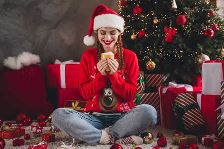 Full size photo of pretty young girl sit floor enjoy eggnog mug wear sweater christmas festive holiday time apartment indoorsの写真素材