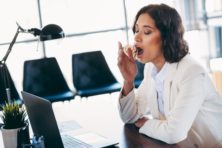 Young woman wearing pink shirt and gray skirt posing against blue background exuding charm and stylish casual fashionの写真素材
