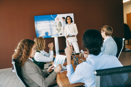 Professional team in business attire collaborating on a project during a formal meeting in a modern...