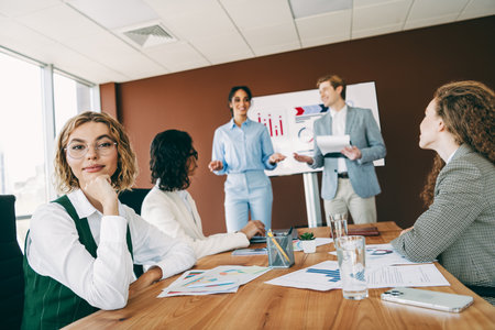 Diverse group of professional colleagues engaged in a collaborative business meeting in a modern...