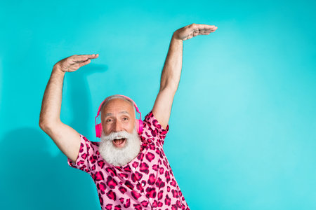 Photo of senior bearded man dance listen music headphones dressed stylish pink leopard print clothes...