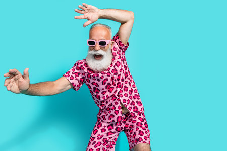 Portrait of funky aged man dance empty space wear leopard print costume isolated on turquoise color backgroundの写真素材
