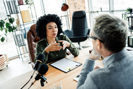 Professional business meeting in modern office involving focused discussion between coworkers showcasing teamwork and strategic planningの写真素材