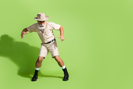 Photo of eco tourist senior man walking careful on tour look down empty space wear safari suit...