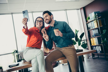 Young professionals coworking in a modern office environment, happily engaging in teamwork and partnershipの写真素材
