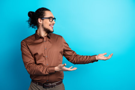 Young professional man in formal brown shirt gesturing with hands, ideal for business and lifestyle...