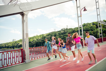 Group of young friends enjoying a cheerful walk on a vibrant day outdoors during summerの写真素材
