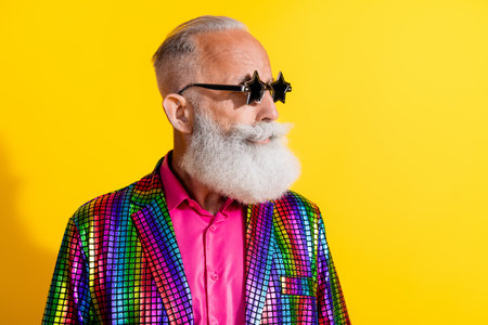 Portrait of eccentric funky aged man star shape sunglass empty space wear shiny costume isolated on yellow color backgroundの写真素材