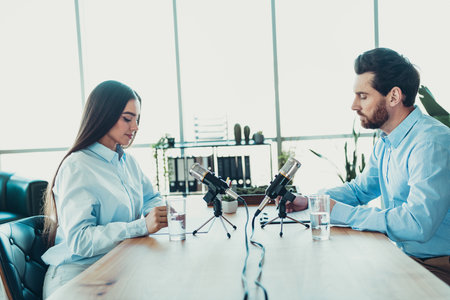 Professional interview session between colleagues in a formal office setting showcasing focused...