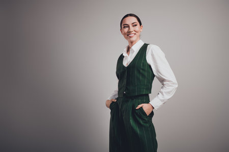Gorgeous Confident Businesswoman in Green Formal Suit Posing Against Grey Studio Background