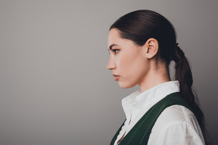 Gorgeous Elegant Businesswoman in Formal Attire Posing Against a Neutral Grey Backgroundの写真素材