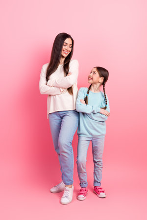 Happy mother and daughter bonding over a moment of joy together against a vibrant pink vertical backgroundの写真素材