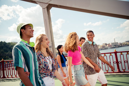 Group of young friends enjoying a summer day outdoors, walking and sharing happy moments in the city togetherの写真素材