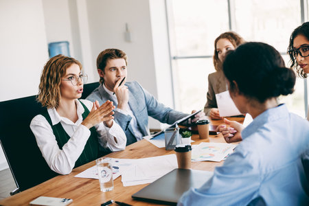 Group of business professionals collaborating during a team meeting in a modern office environment