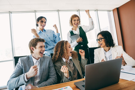 Team members celebrate success with enthusiasm and energy in a modern office workspace