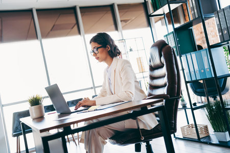 Professional businesswoman working at a desk in a modern office workspaceの写真素材