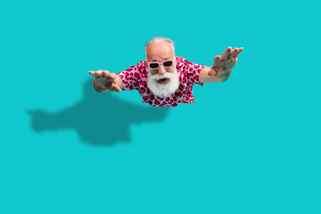 Full length photo of handsome bearded grandpa flying enjoy summer dressed stylish pink leopard print garment isolated on cyan backgroundの写真素材