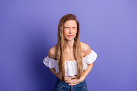 Young woman in stylish white top posing on vibrant background expressing emotions in cheerful trendy...